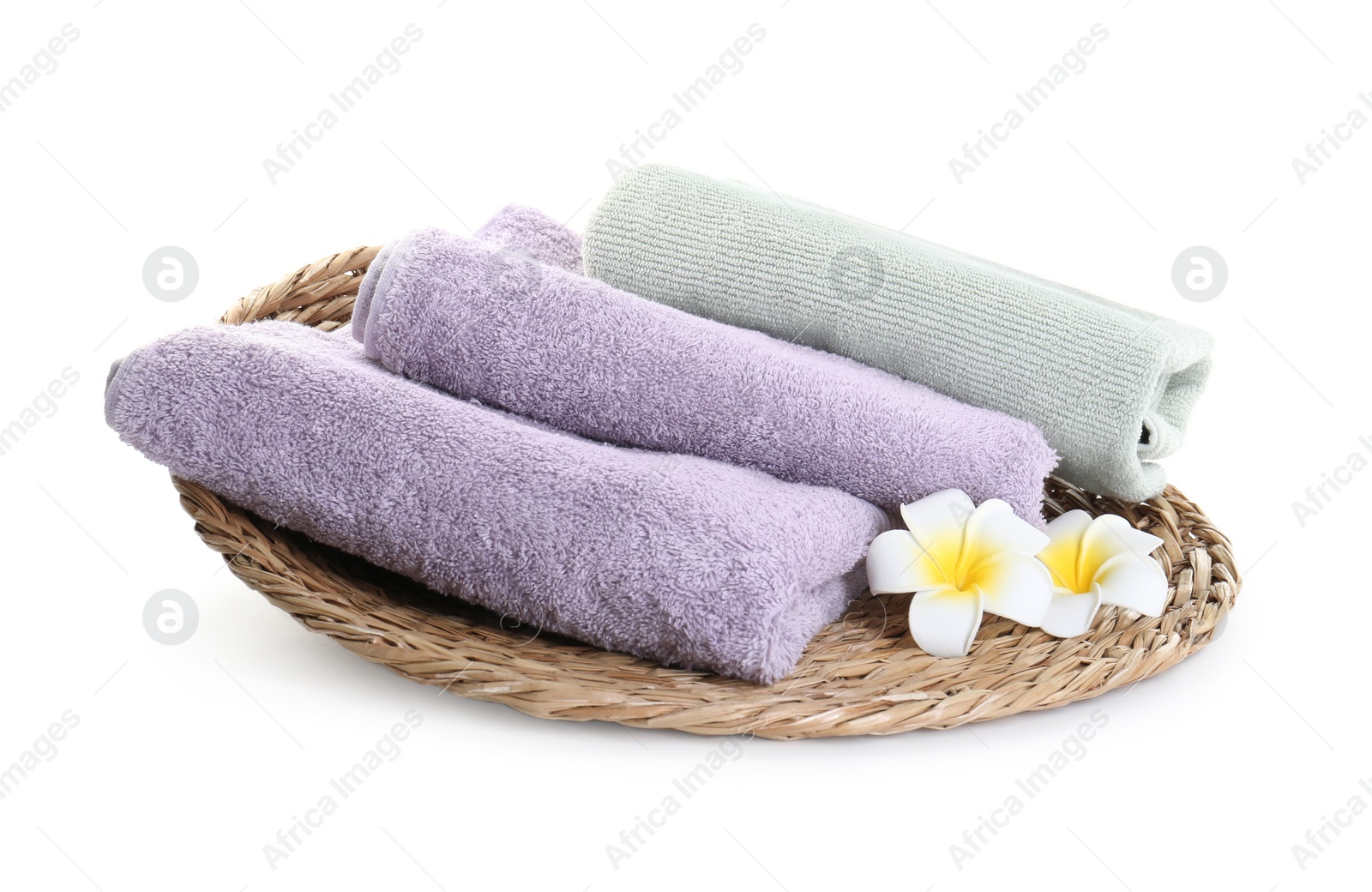Photo of Different folded terry towels and plumeria flowers isolated on white