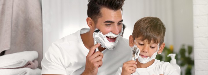 Image of Father and son having fun while shaving in bathroom. Banner design