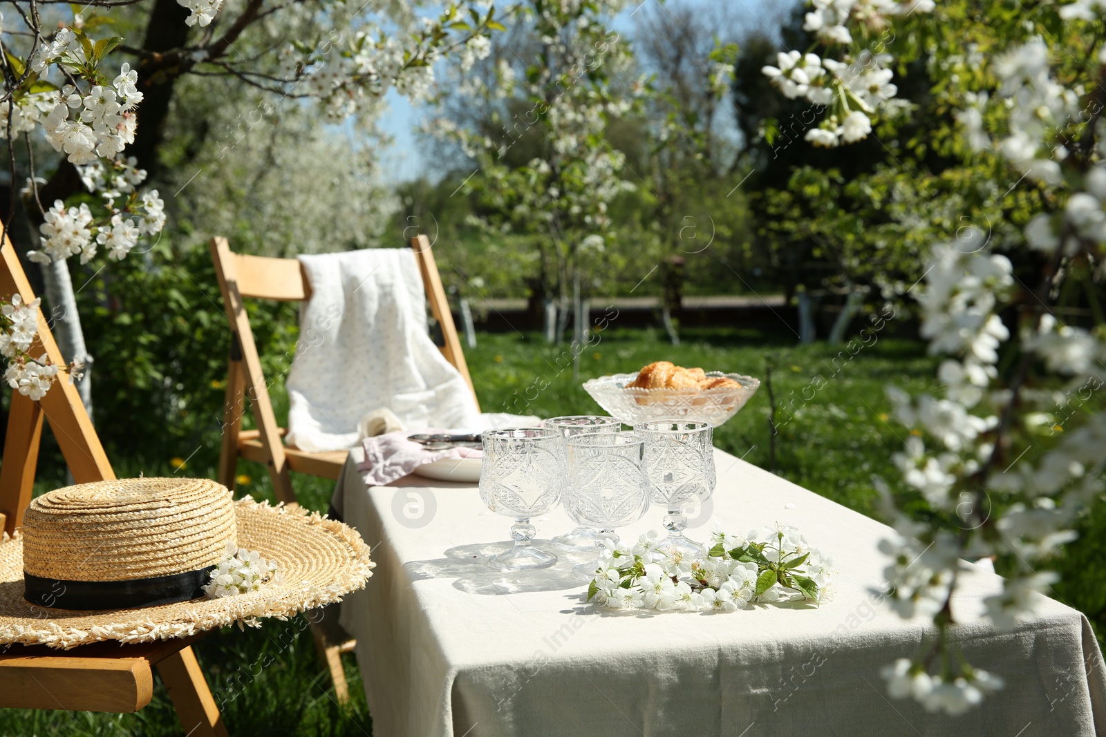 Photo of Beautiful table setting with spring flowers in garden on sunny day