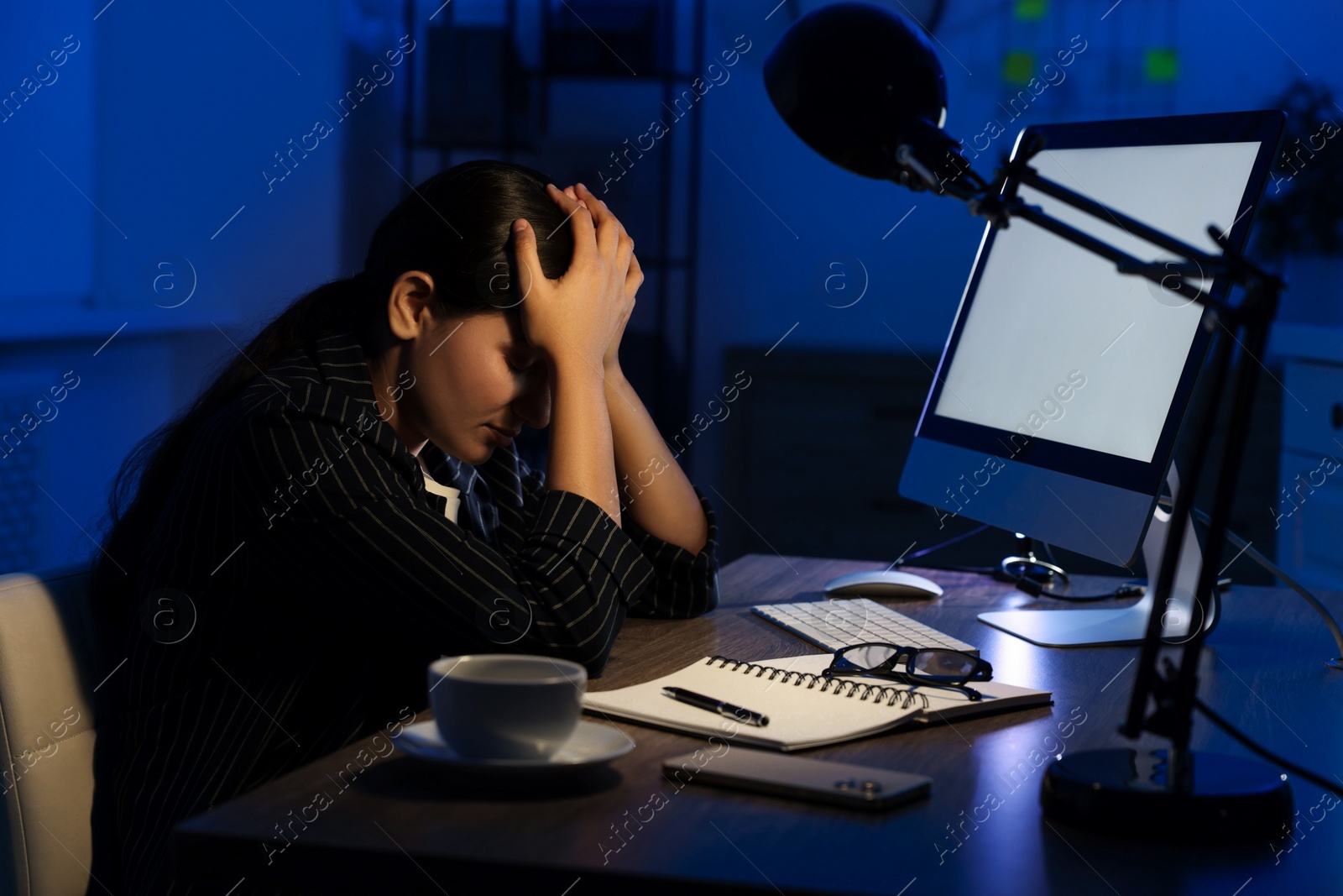 Photo of Tired overworked businesswoman at night in office