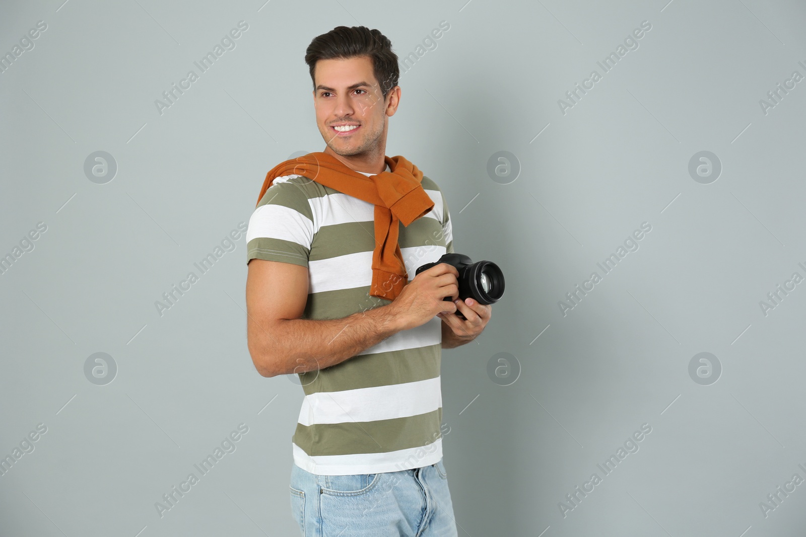 Photo of Professional photographer working on light grey background in studio