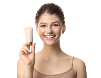 Beautiful girl with tube of foundation on white background