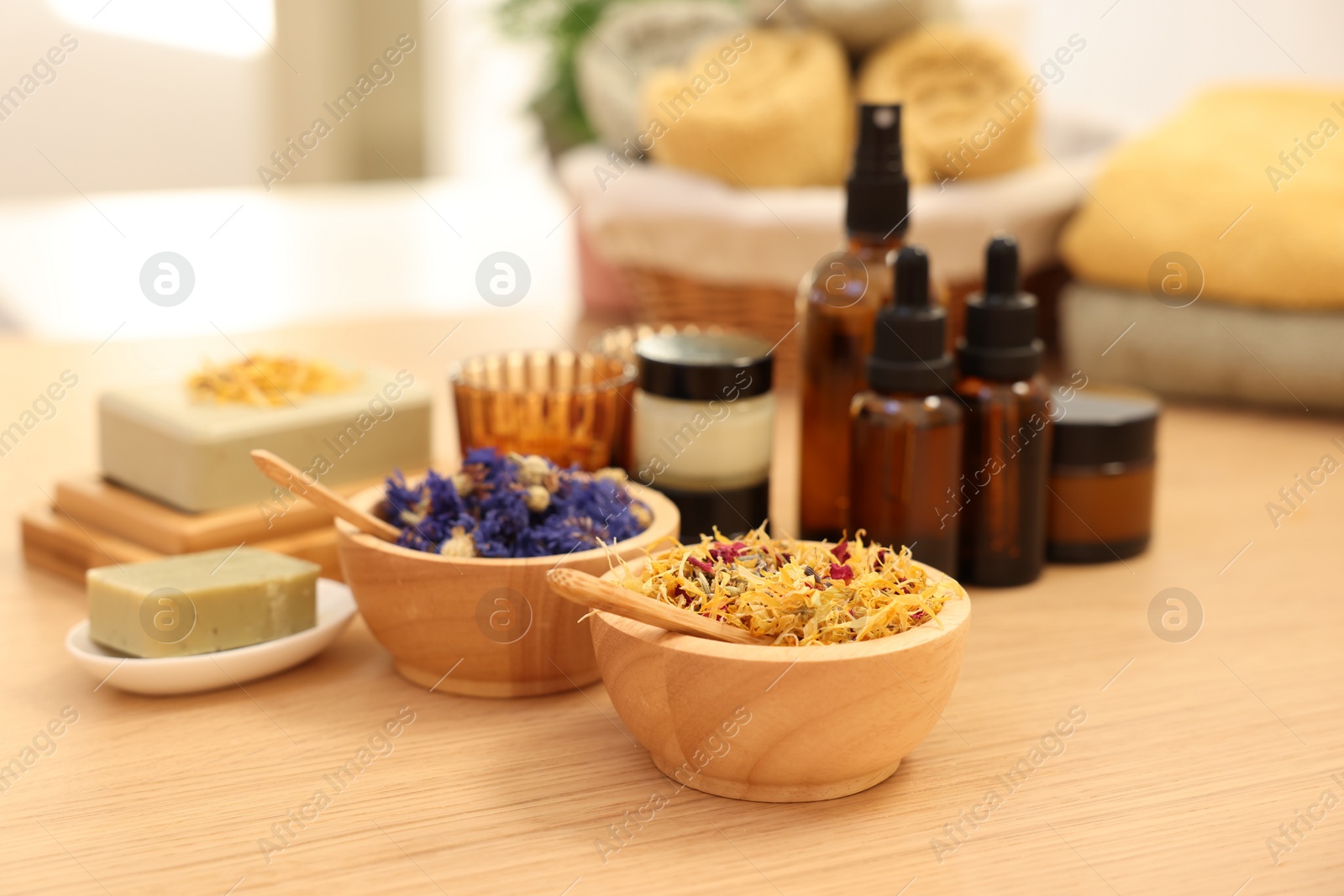 Photo of Dry flowers and soap bar on wooden table indoors. Spa time