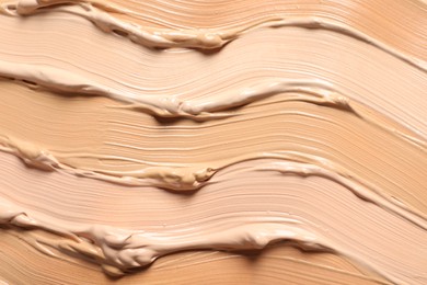 Photo of Samples of skin foundation as background, closeup