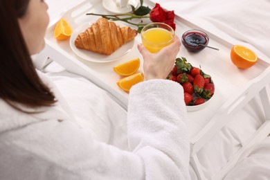 Woman having breakfast in bed at home, closeup