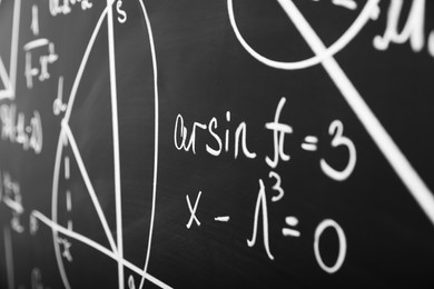 Photo of Mathematical formulas written with chalk on blackboard, closeup
