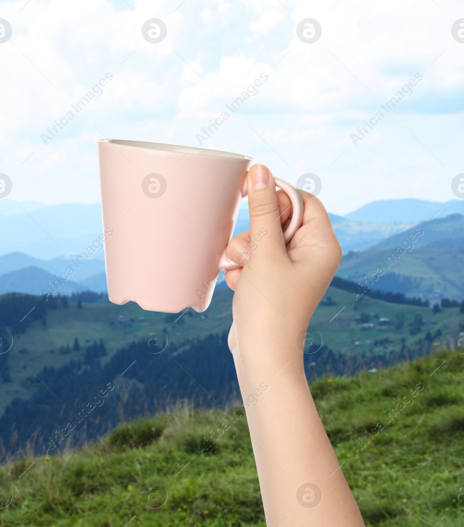 Image of Closeness to nature. Woman holding cup in mountains, closeup