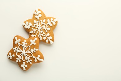 Tasty Christmas cookies with icing on white background, flat lay. Space for text