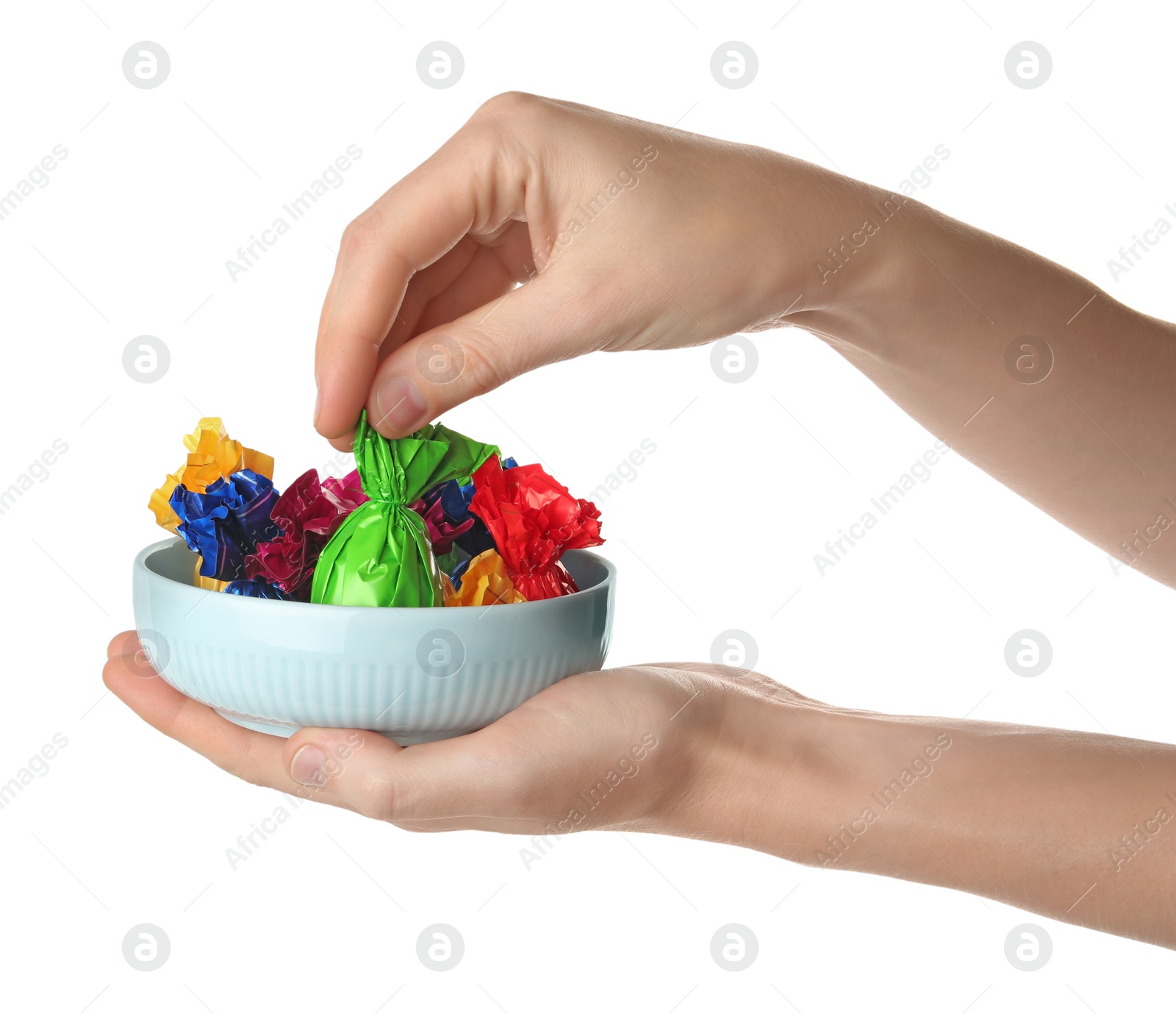 Photo of Woman taking candy in green wrapper from bowl isolated on white, closeup