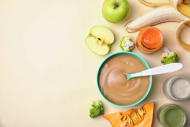 Photo of Flat lay composition with bowl of healthy baby food and space for text on color background