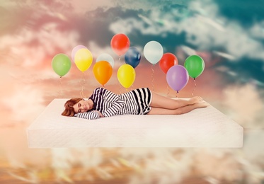 Image of Sweet dreams. Bright cloudy sky with air balloons around sleeping woman 
