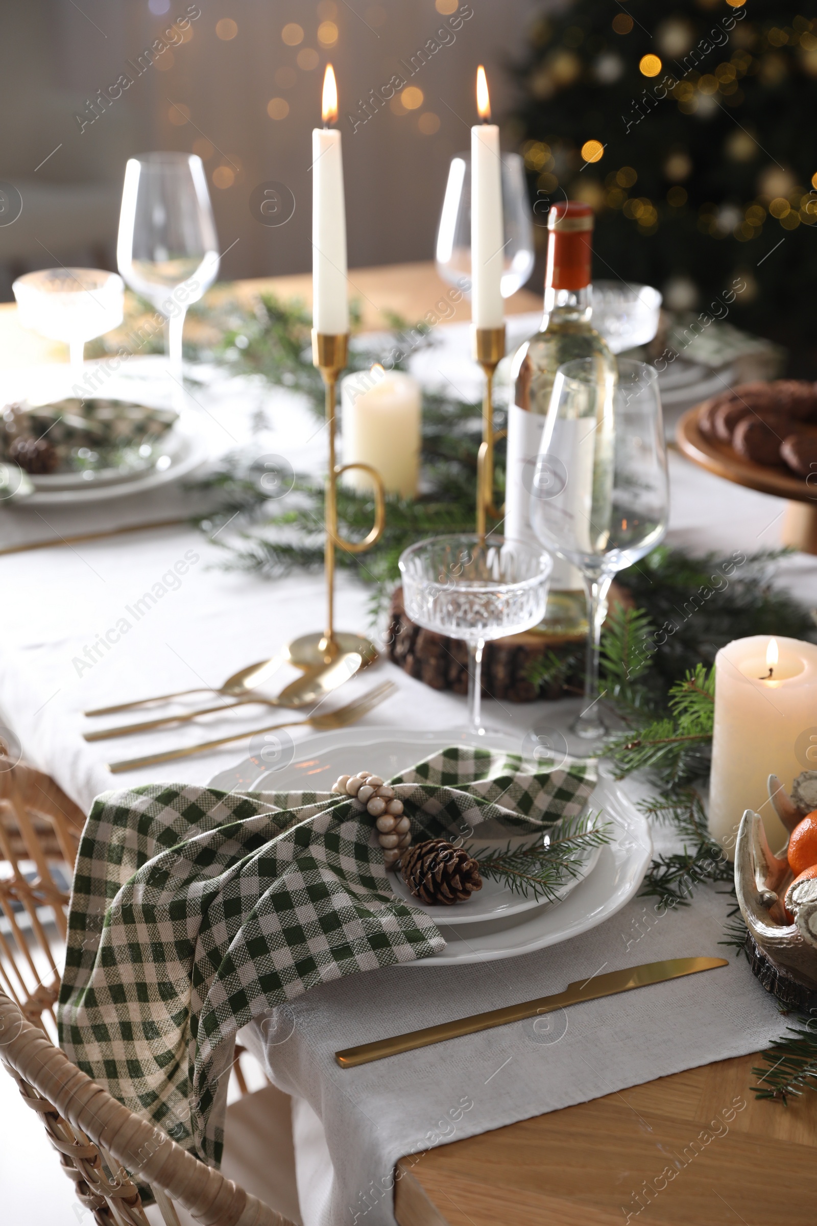 Photo of Christmas table setting with festive decor and dishware indoors