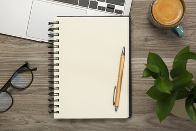 Photo of Flat lay composition with notebook and laptop on wooden table