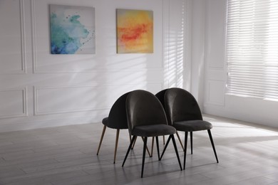 Chairs and beautiful paintings in art gallery