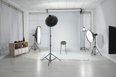Photo of Empty chair and professional equipment in photographer's studio