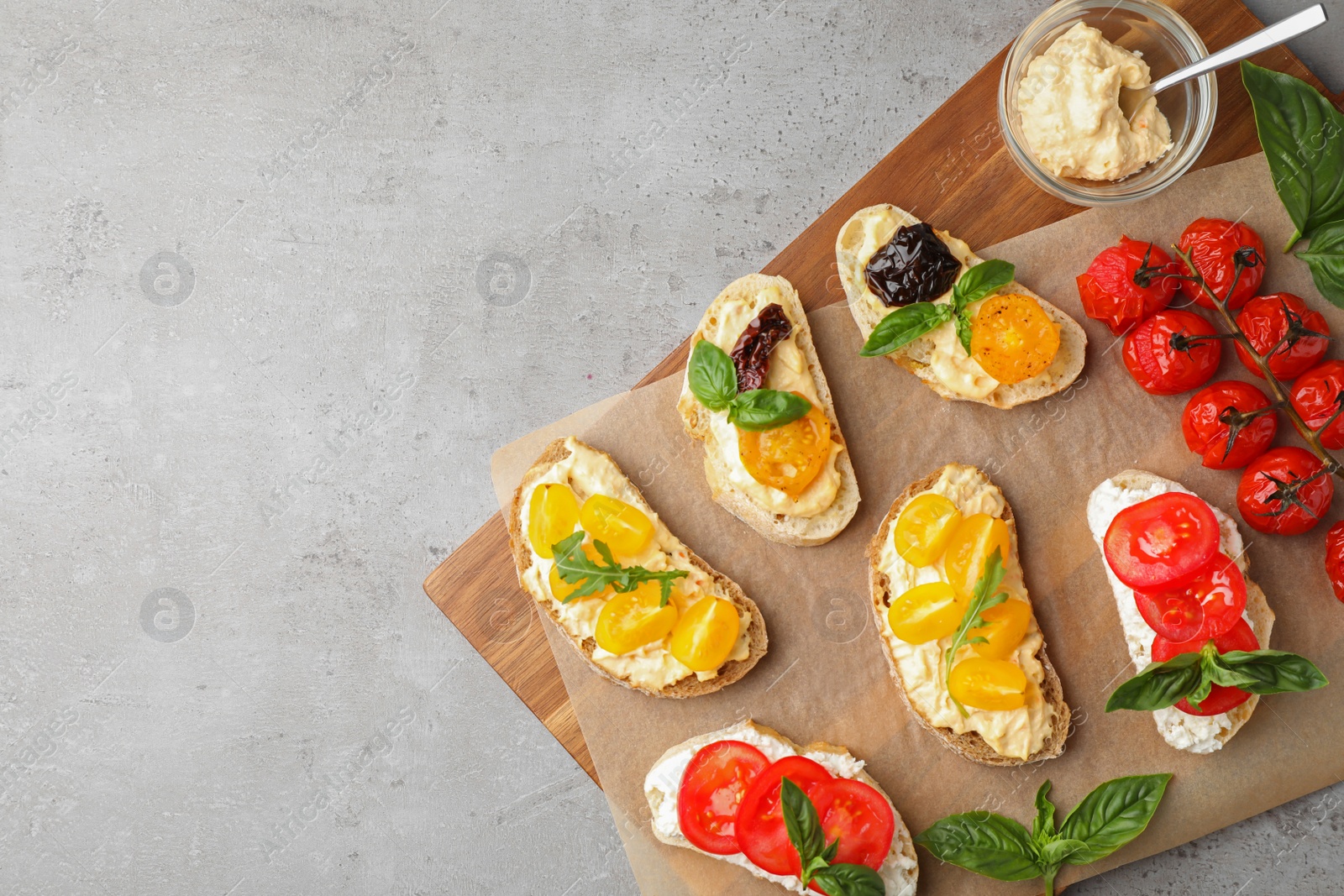 Photo of Tasty fresh tomato bruschettas on grey table, flat lay. Space for text