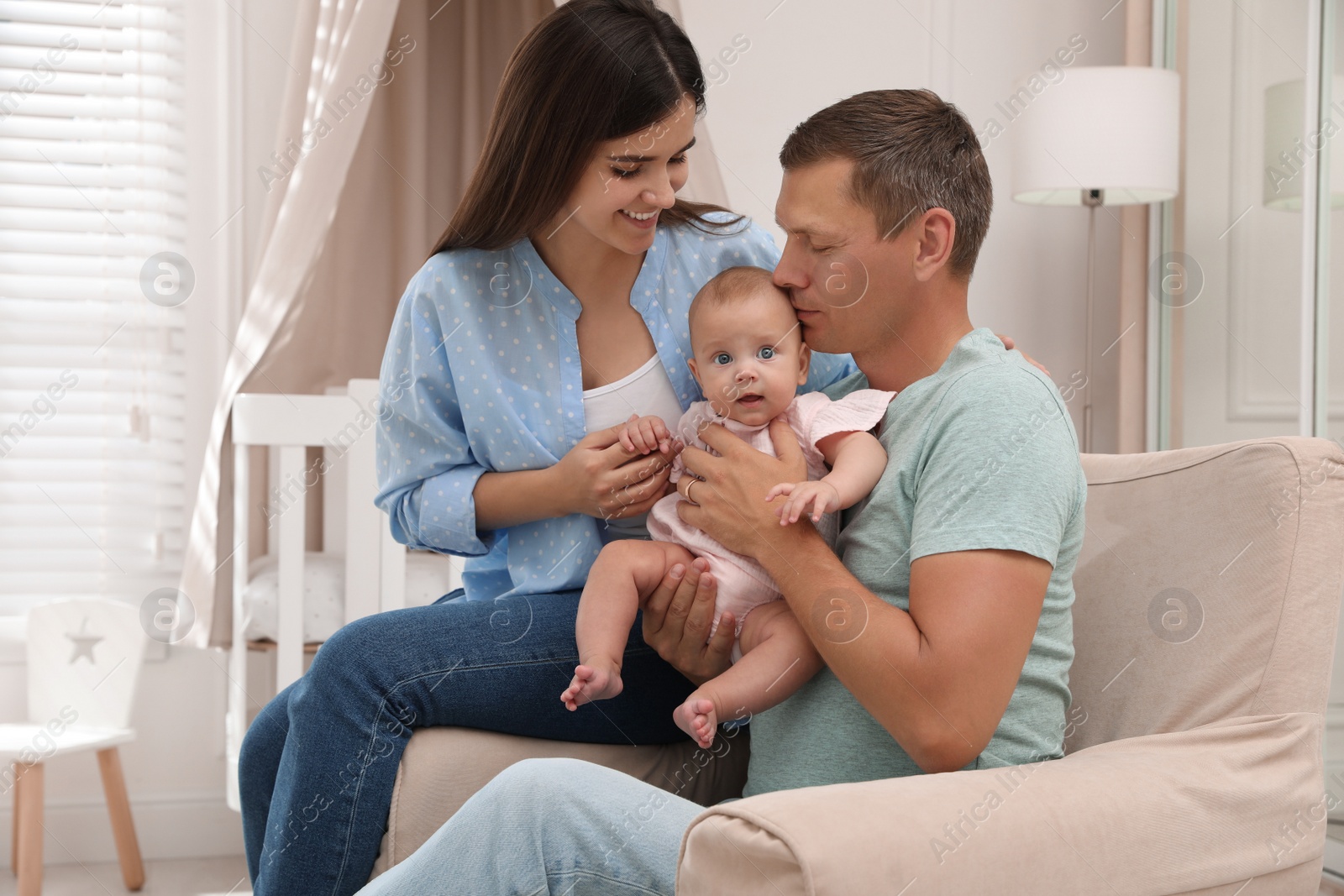 Photo of Happy family with their cute baby at home