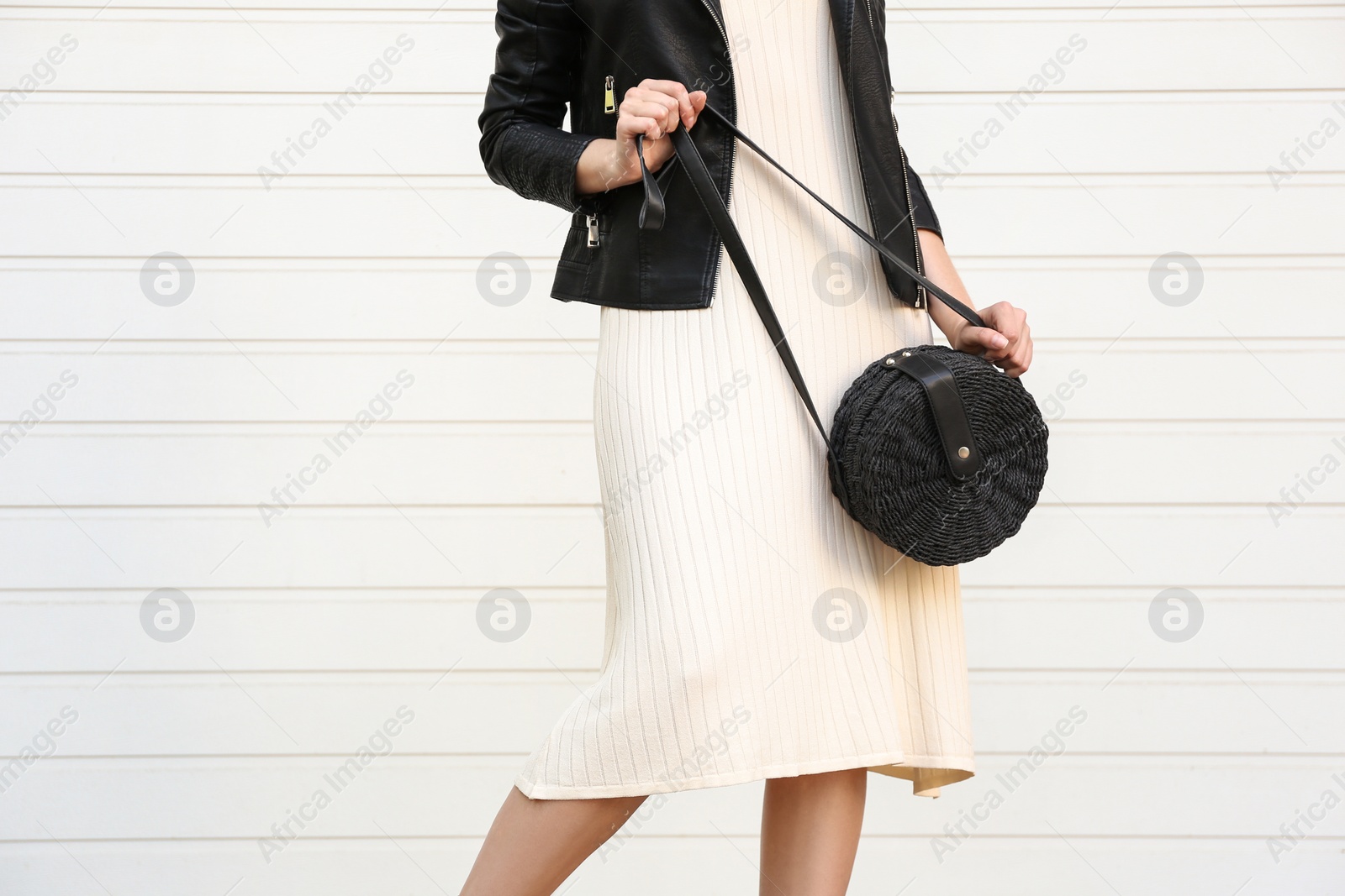 Photo of Young woman with stylish handbag near white wall, closeup