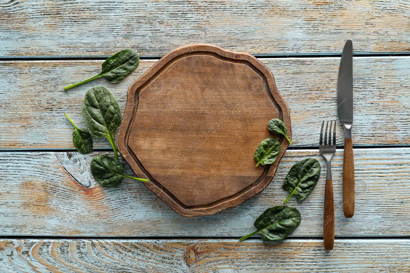 Photo of Food photography. Fresh basil, board and cutlery on wooden table, flat lay