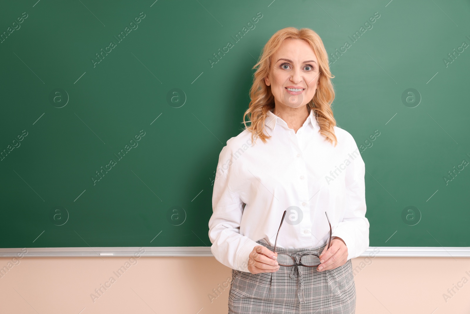 Photo of Happy professor with glasses near green board, space for text