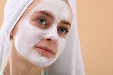 Woman with face mask on beige background, closeup and space for text. Spa treatments