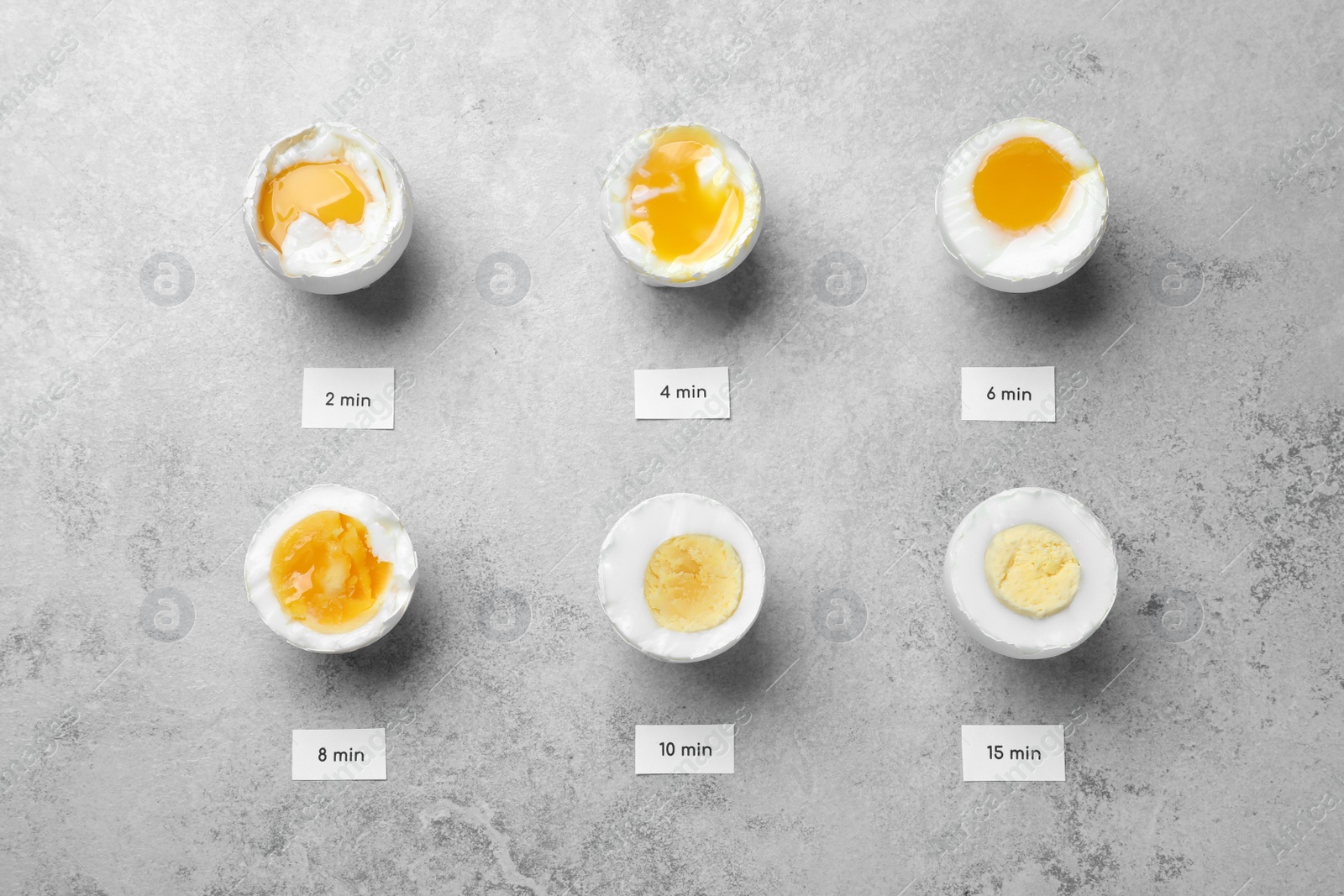 Photo of Different cooking time and readiness stages of boiled chicken eggs on light grey table, flat lay
