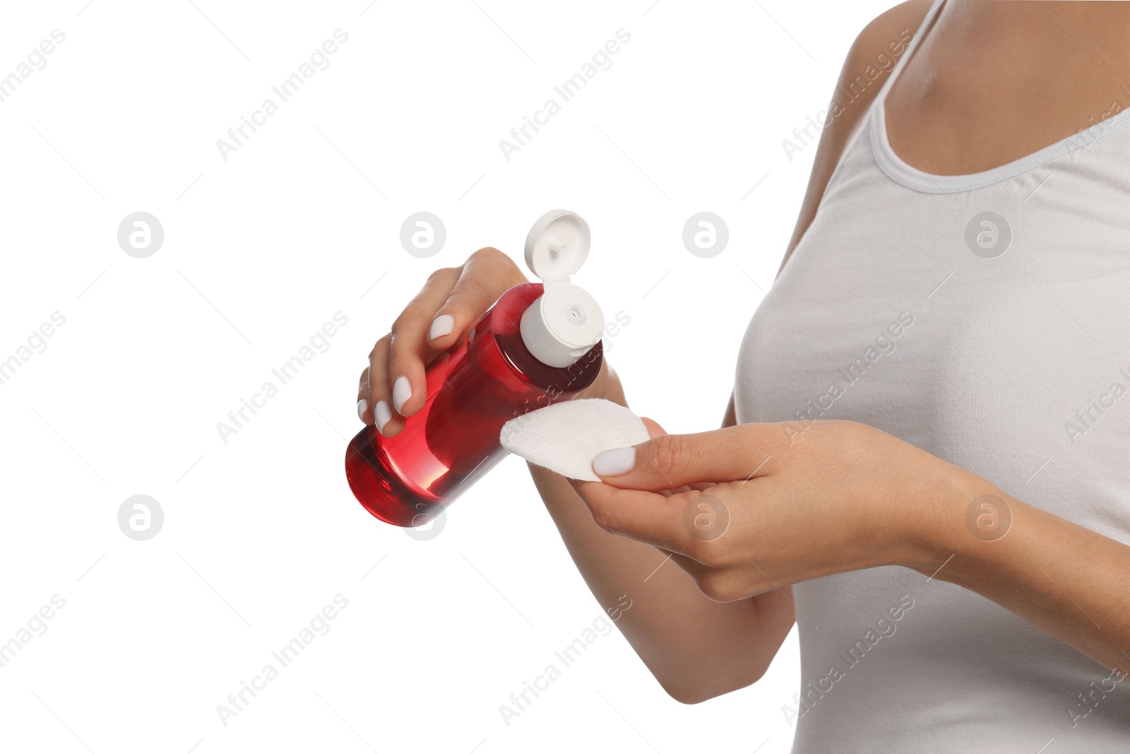 Photo of Woman pouring micellar water onto cotton pad on white background, closeup