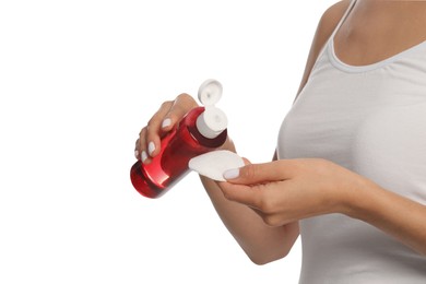 Photo of Woman pouring micellar water onto cotton pad on white background, closeup
