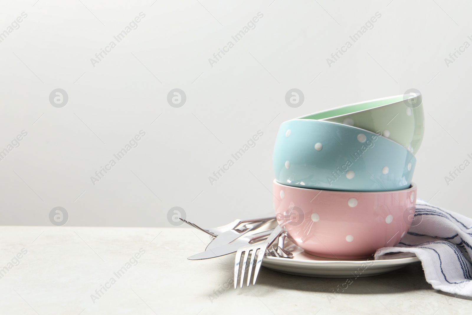 Photo of Beautiful ceramic dishware and cutlery on light grey table, space for text