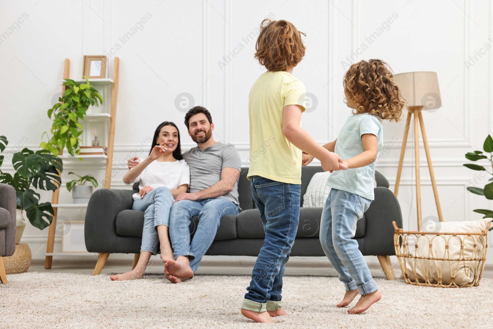 Photo of Children dancing while their parents looking at them in room