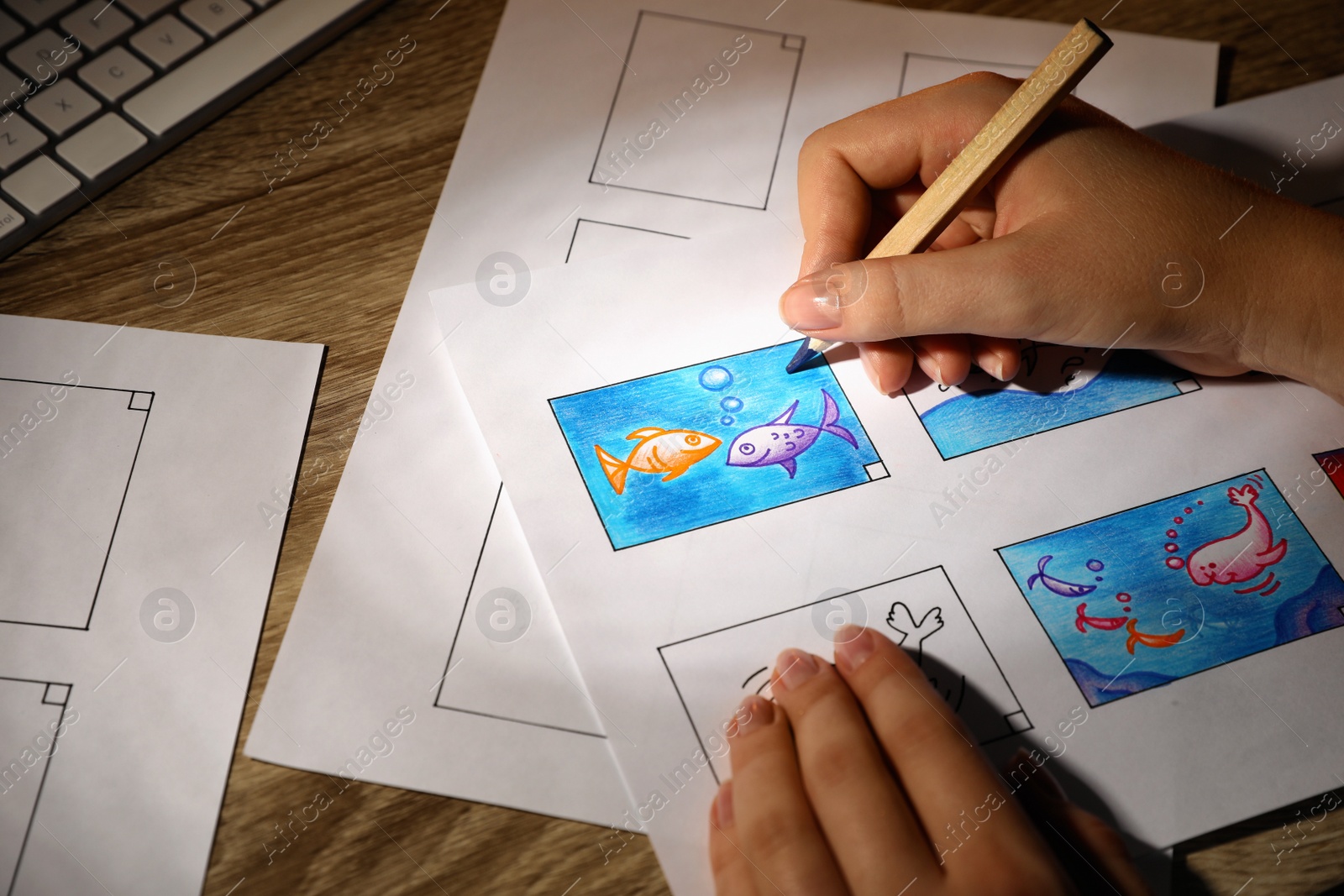 Photo of Woman drawing cartoon sketch in storyboard at workplace, closeup. Pre-production process