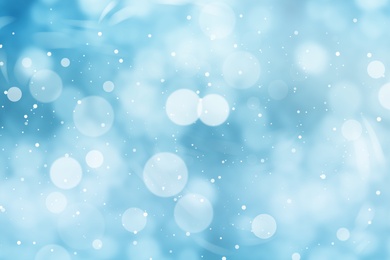 Image of Abstract snowfall on light blue background, bokeh effect
