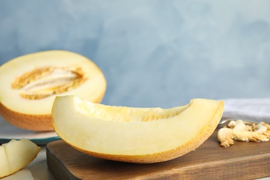 Wooden board with tasty cut ripe melon on table