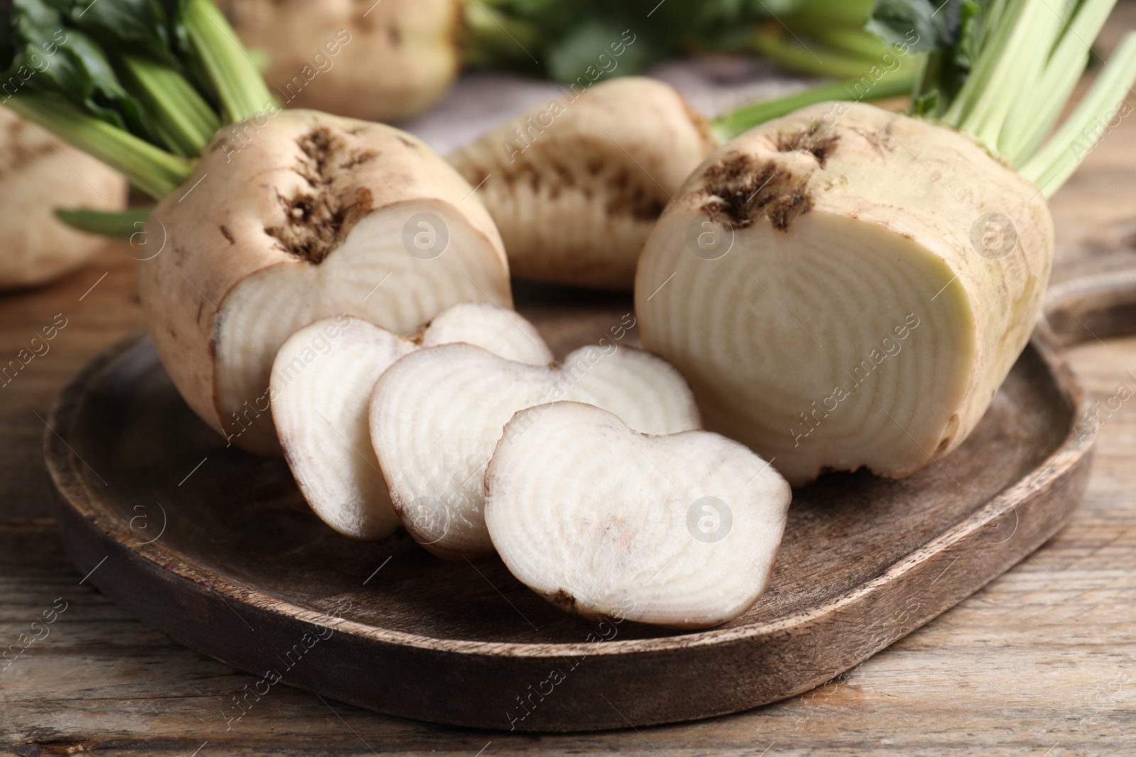 Photo of Cut sugar beets on wooden table, closeup