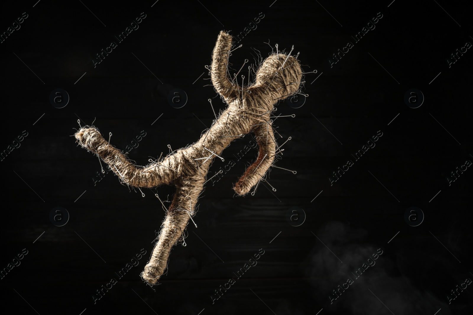 Photo of Voodoo doll with pins on black wooden background