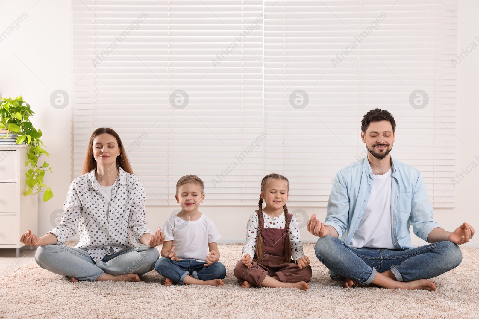 Photo of Family meditating together at home. Harmony and zen