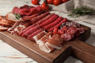 Photo of Cutting board with different sliced meat products served on table