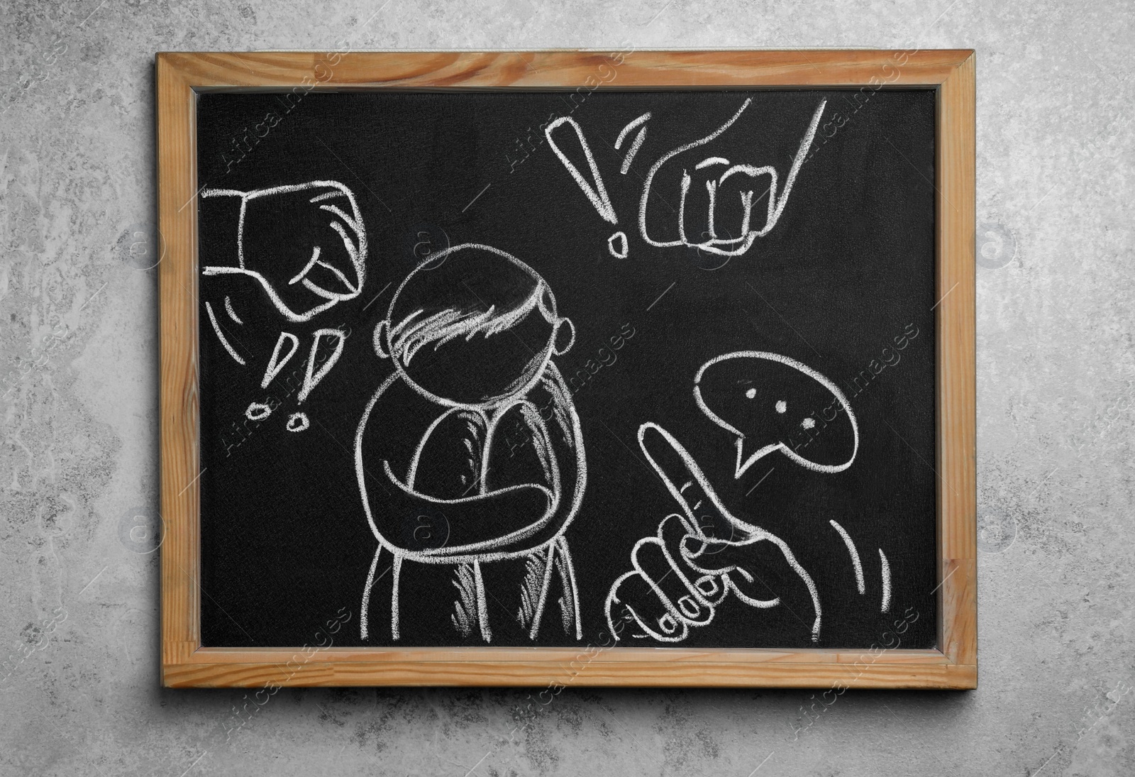 Photo of Blackboard with drawn people bullying sad human on grey background, top view