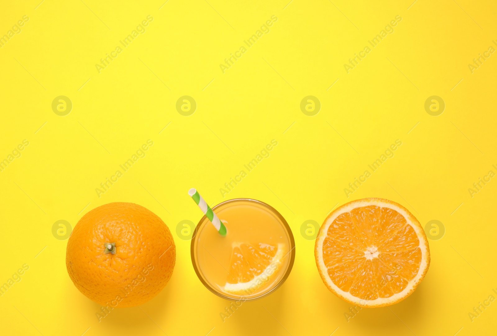 Photo of Glass of orange juice and fresh fruits on yellow background, flat lay. Space for text