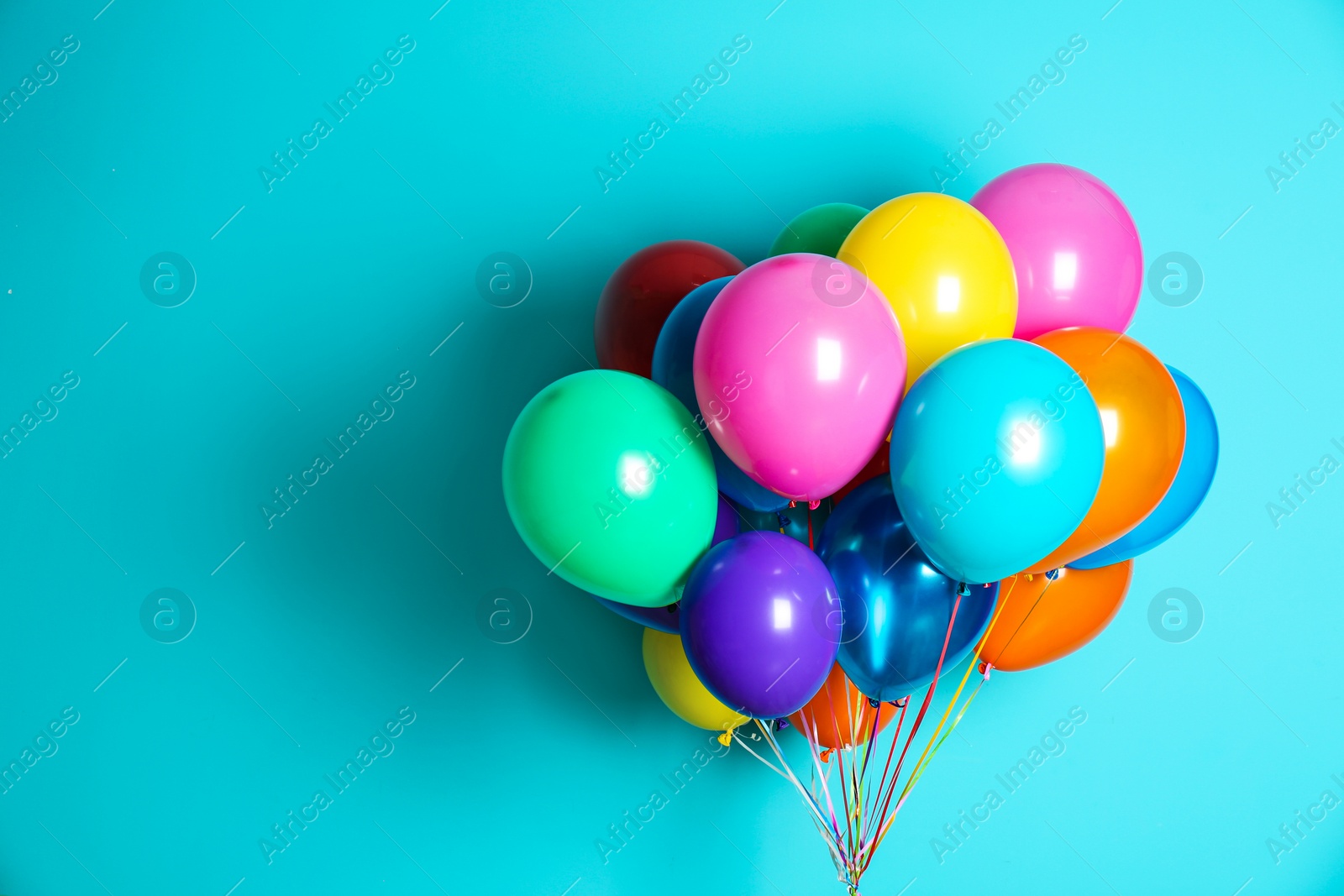 Photo of Bunch of bright balloons on color background with space for design