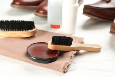 Shoe care accessories on white wooden table, closeup