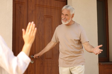 Photo of Friendly relationship. Neighbors greeting each other near house outdoors