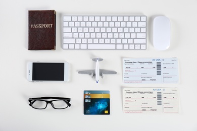Photo of Flat lay composition with airplane and computer keyboard on light background. Travel agency concept