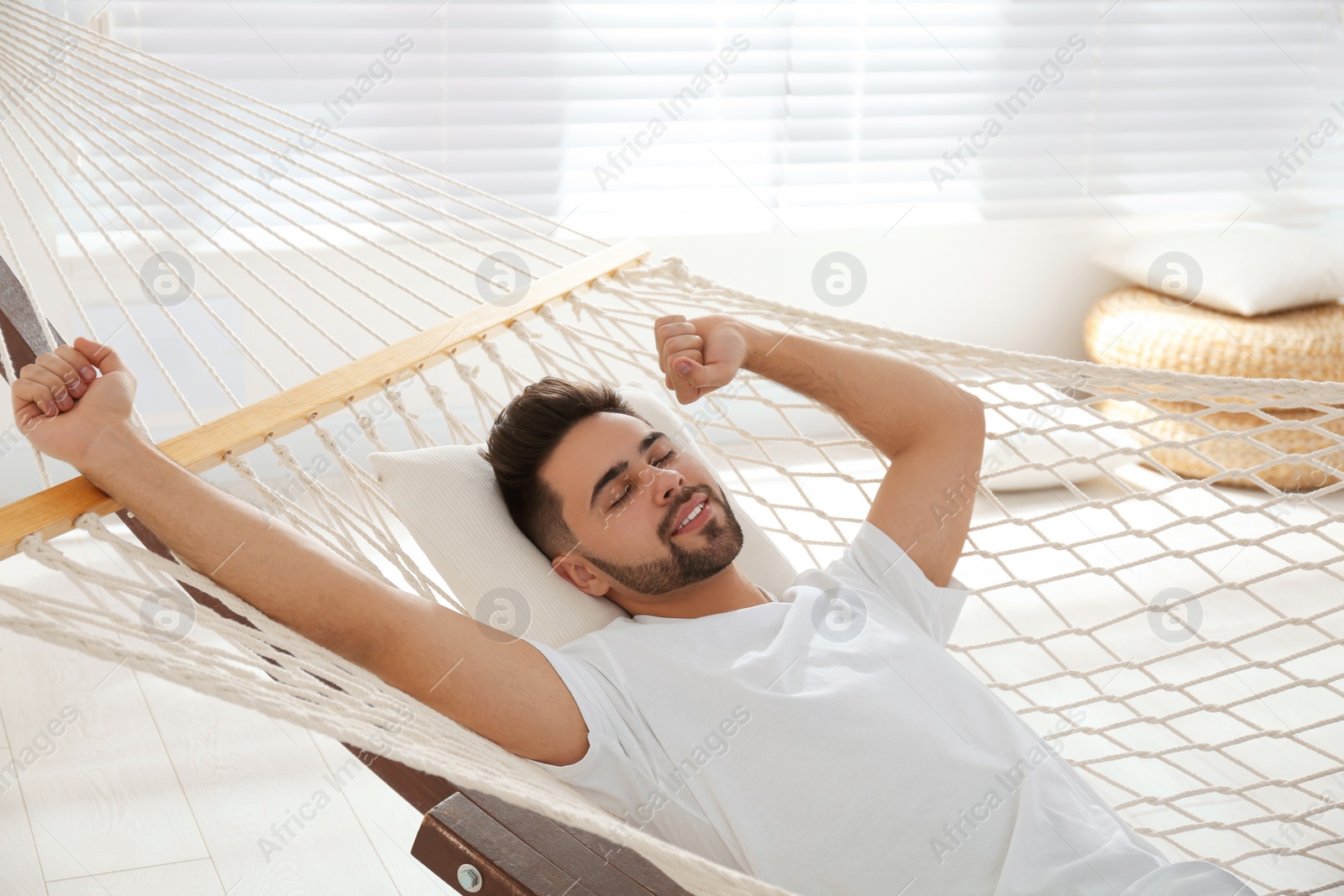 Photo of Young man relaxing in hammock at home