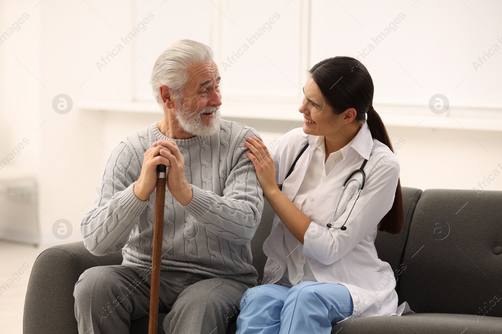 Photo of Health care and support. Nurse laughing with elderly patient in hospital