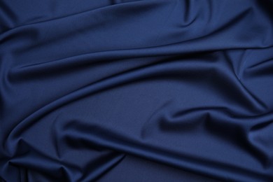 Photo of Crumpled dark blue silk fabric as background, top view