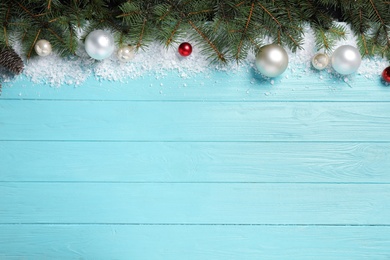 Christmas decoration with white snow on light blue wooden background, flat lay. Space for text