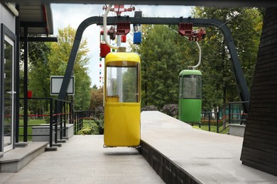 View of cableway with bright cabins in park on autumn day