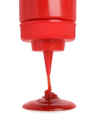 Photo of Pouring tasty red ketchup from bottle isolated on white