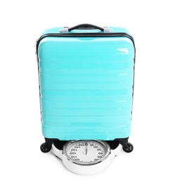 Weighing stylish suitcase on scales, white background